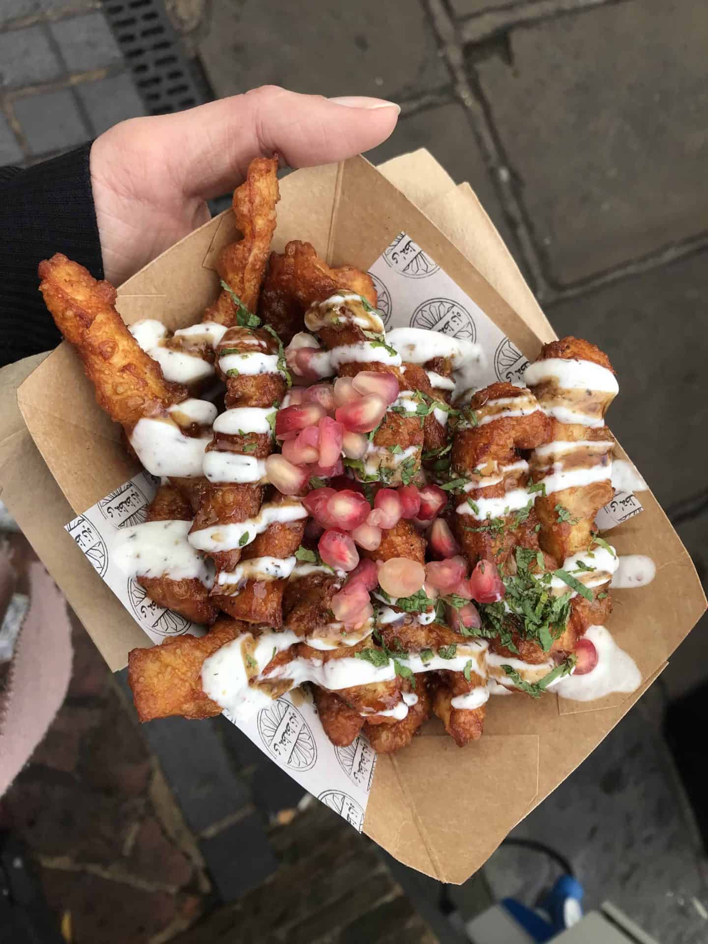 A serving of halloumi fries with sauce and pomegranate.