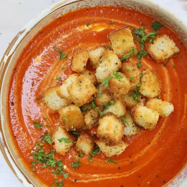 Croutons on top of a bowl of tomato soup.