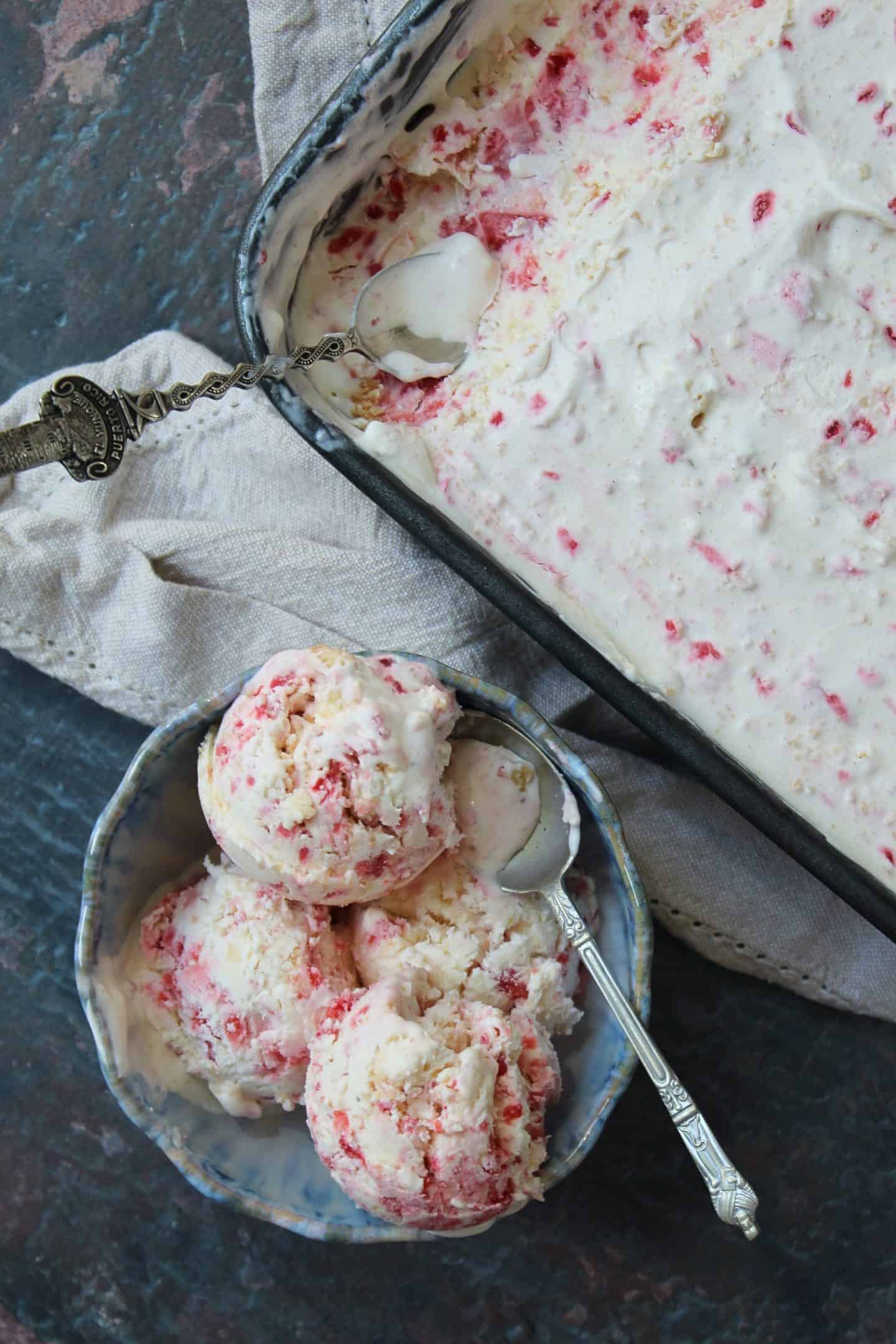a scoop of strawberry cheesecake ice cream with a bowl of ice cream.
