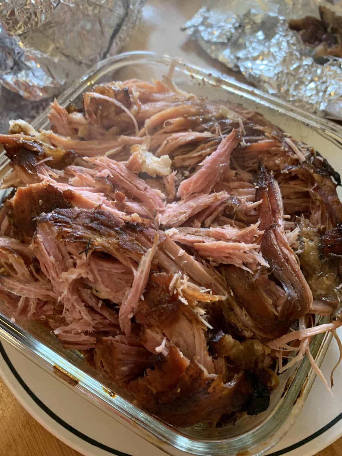 All the slow cooker ham shredded in a glass dish.