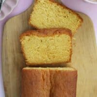 A gluten free Madeira cake on a wooden chopping board.