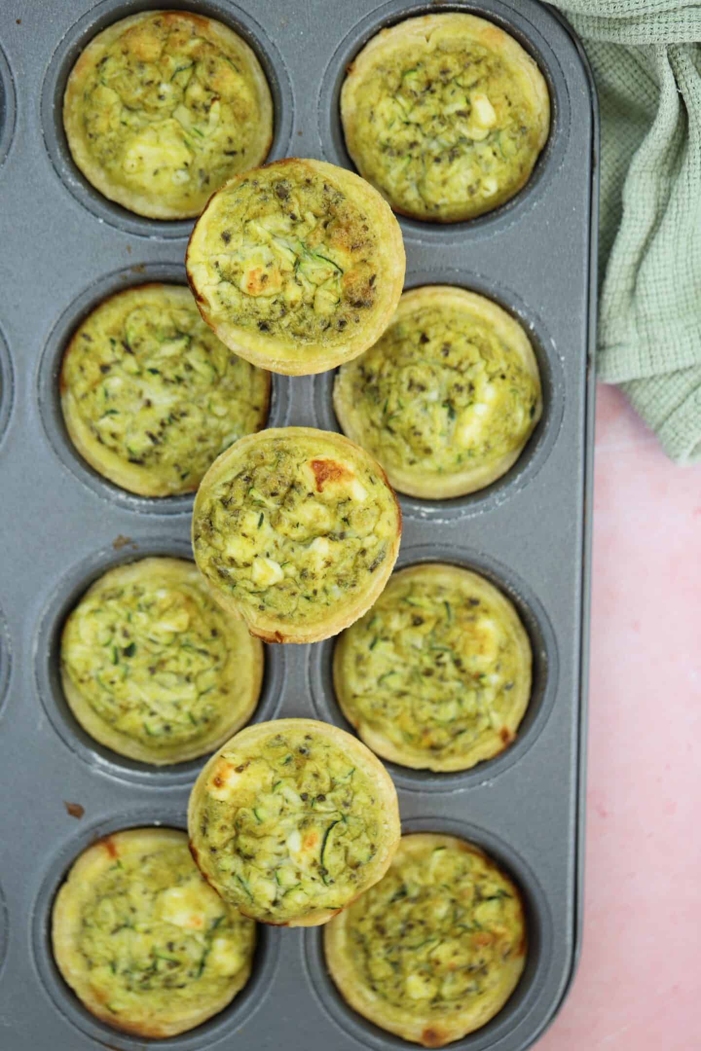 Gluten free mini quiches on a pink worktop.