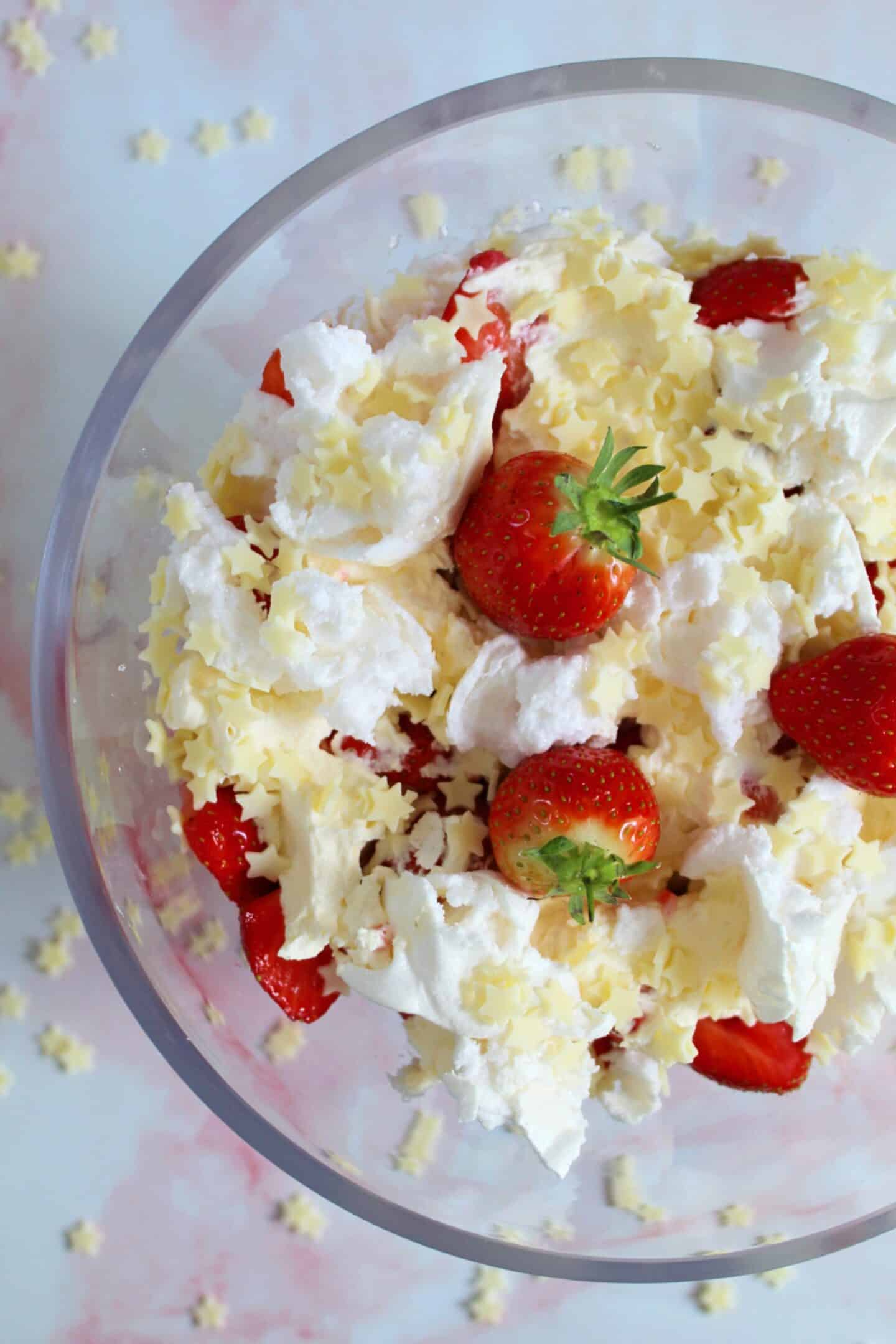 A bowl of Eton mess with white chocolate stars on top.