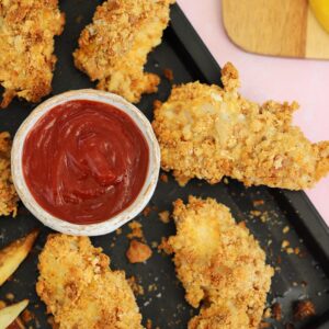 Tray of gluten free fish goujons with tomato ketchup.