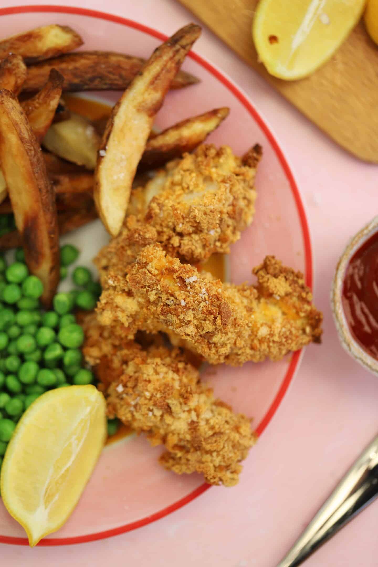 A plate of gluten free cod goujons with peas.