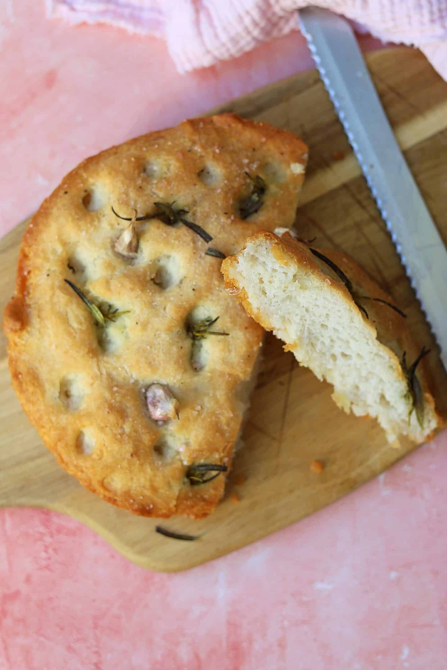 A round focaccia loaf with a slice cut out.