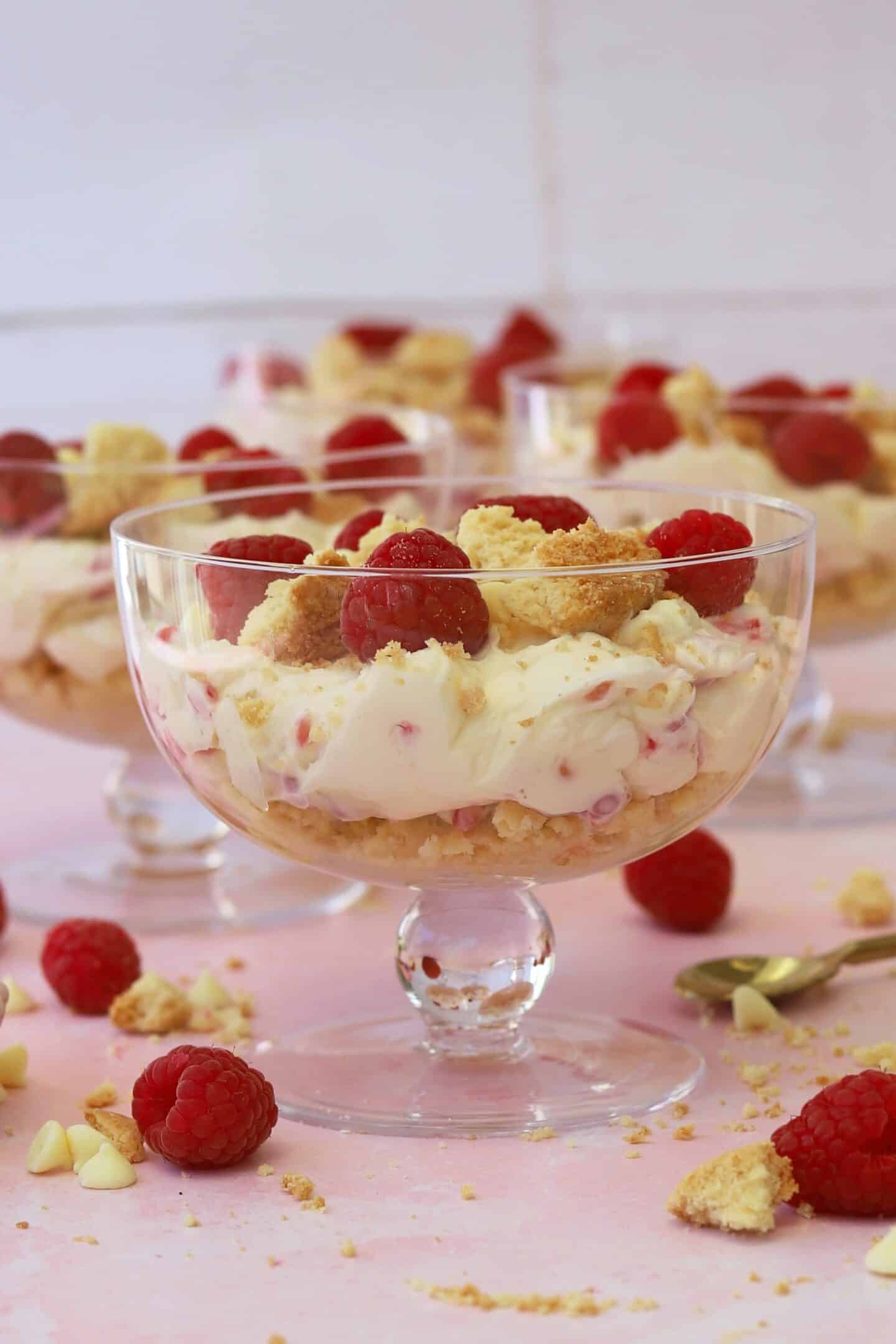 Raspberry and white chocolate cheesecakes in individual glass dishes.