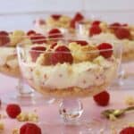 Raspberry and white chocolate cheesecakes in individual glass dishes.