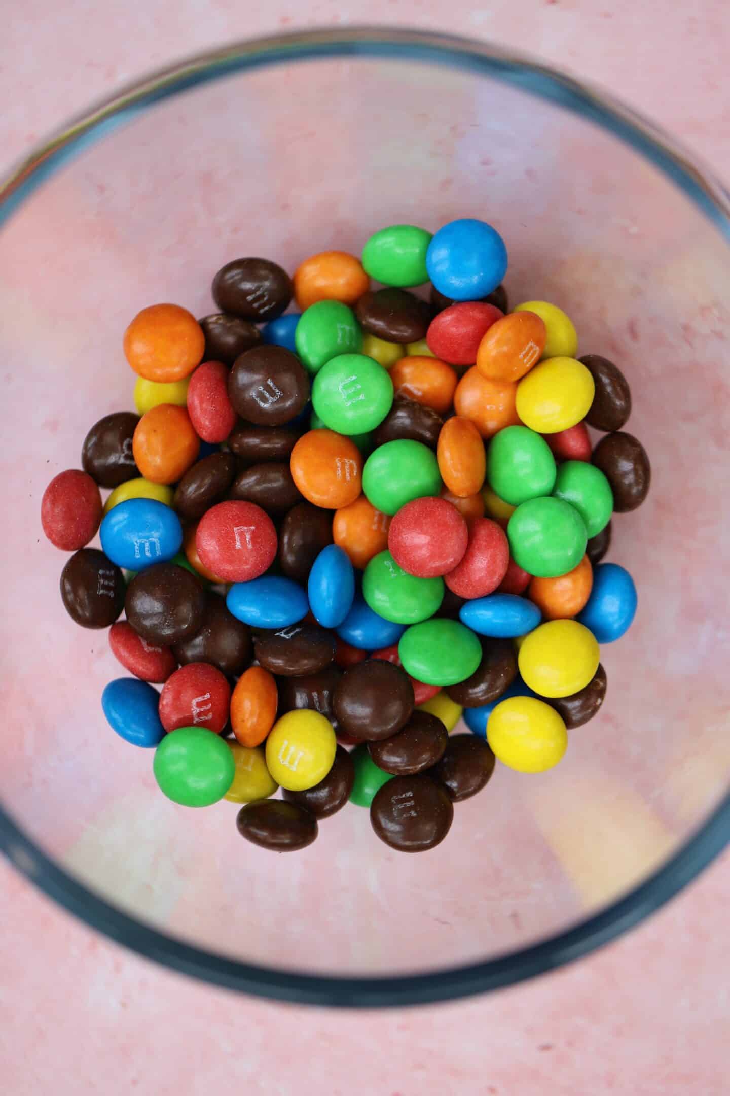 A glass bowl filled with M&M candies.