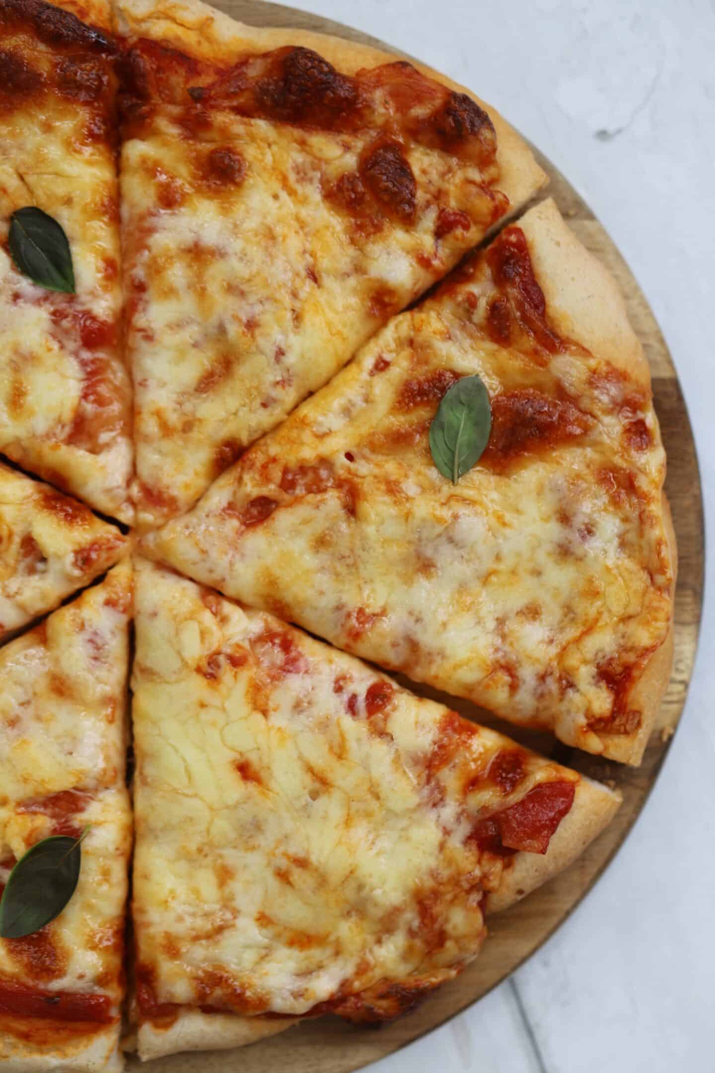 A cheese pizza on a wooden board.