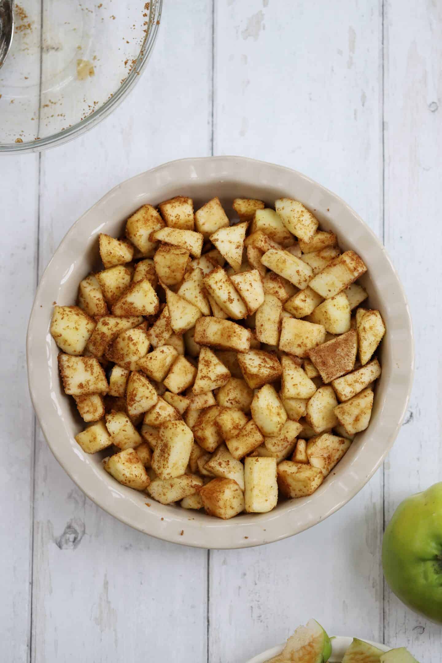 Apples with sugar and cinnamon in a crumble dish.