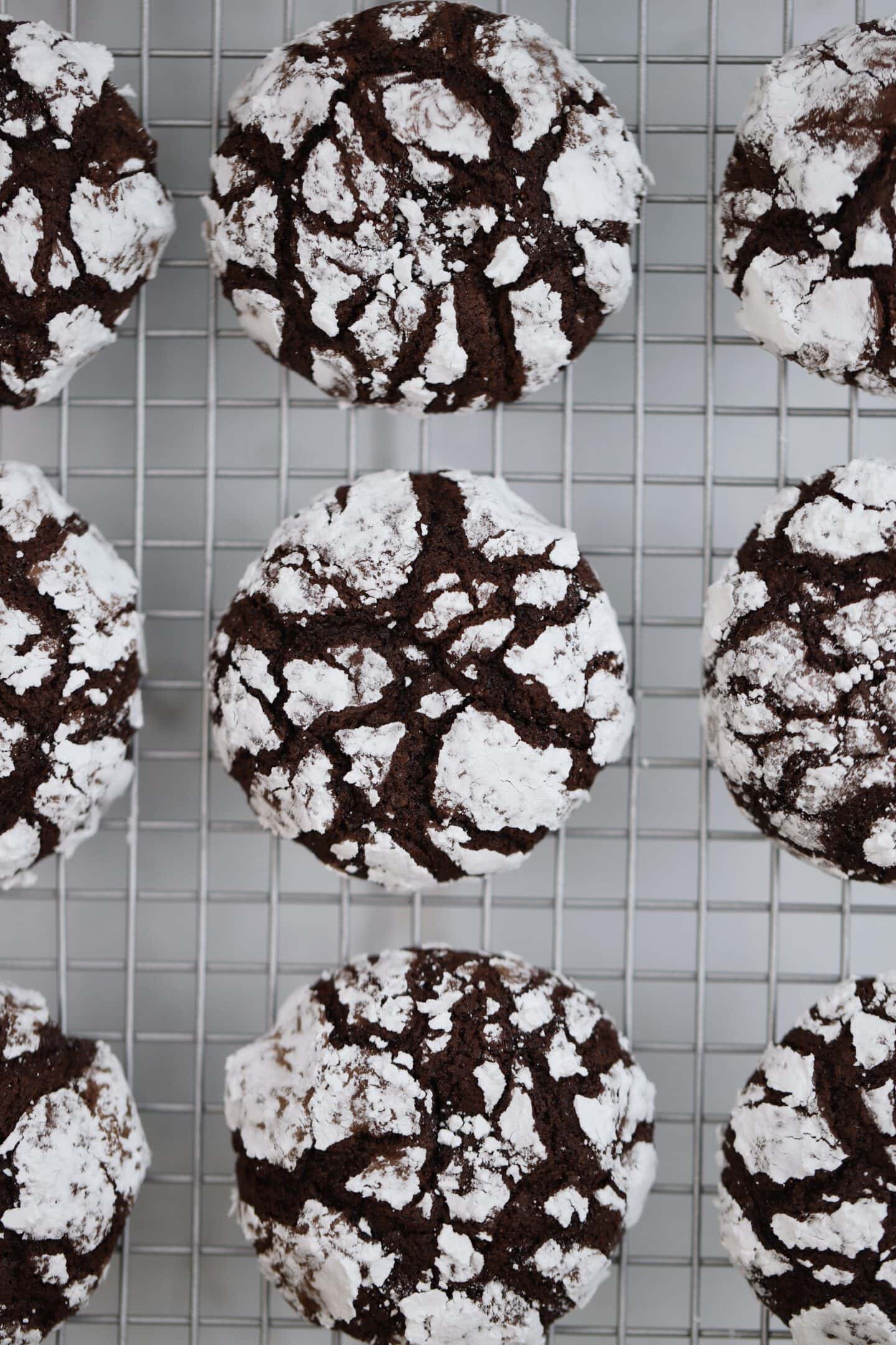 Chocolate crinkle cookies on a cooling rack.