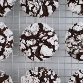 Chocolate crinkle cookies on a cooling rack.