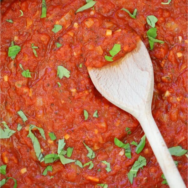 A pan of gluten free marinara sauce with a wooden spoon.