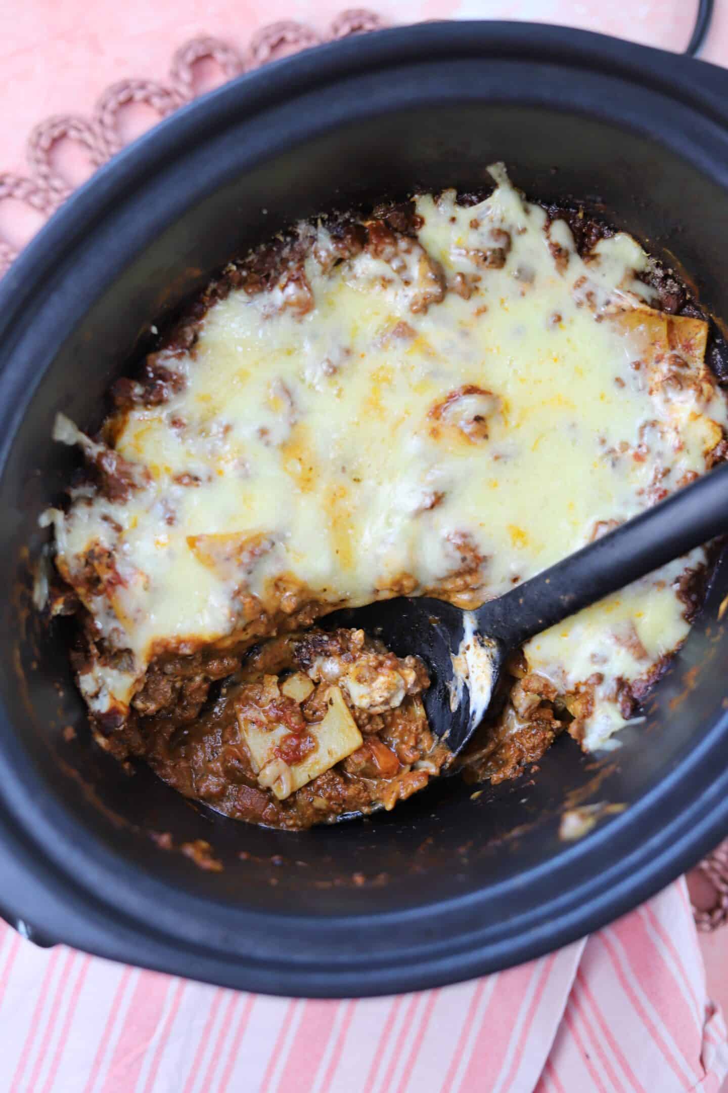 Lasagne in the slow cooker with a portion scooped out.