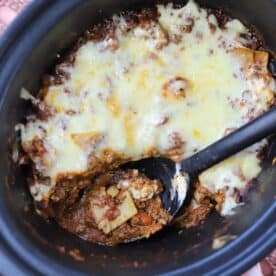 Lasagne in the slow cooker with a portion scooped out.