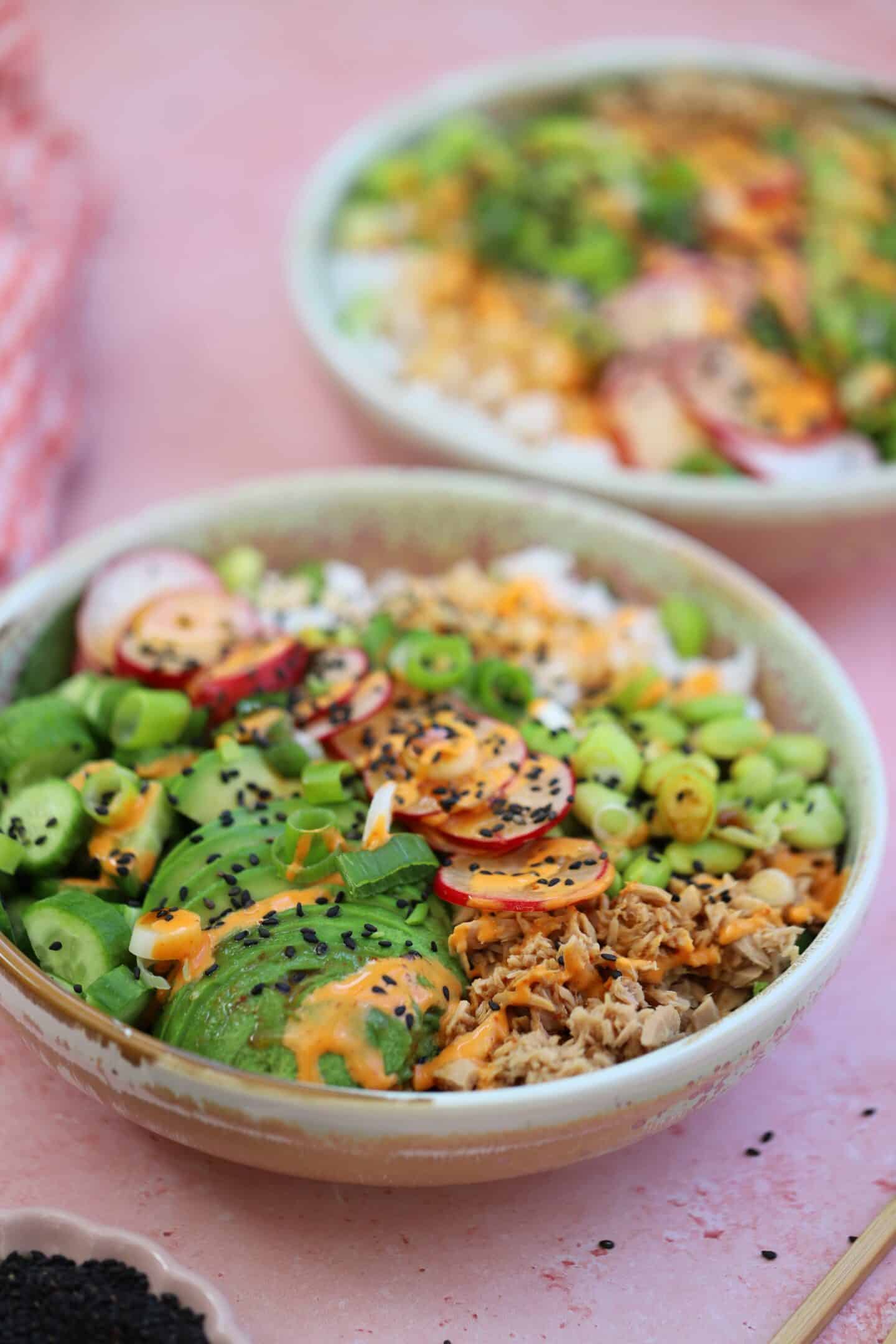 Tuna sushi bowls on a pink backdrop.