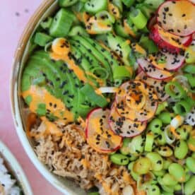 Close up of a tuna sushi bowl with edamame beans, avocado and spicy mayo sauce.