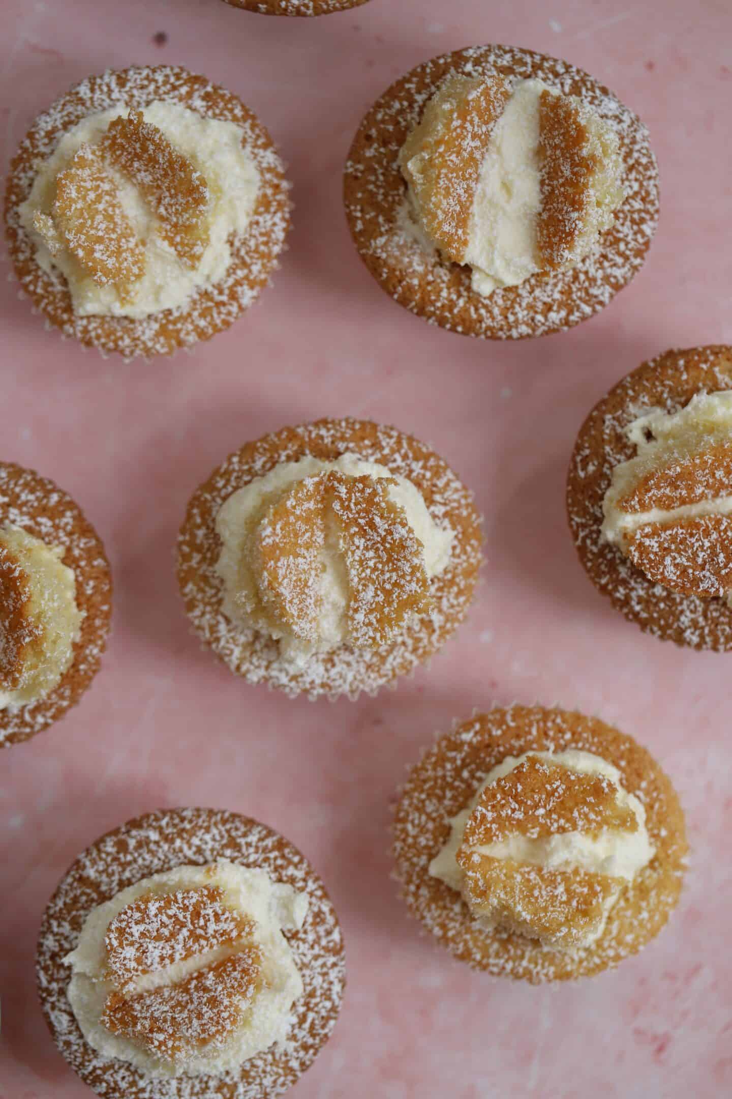 Overhead shot of gluten free butterfly cakes on a pink backdrop.