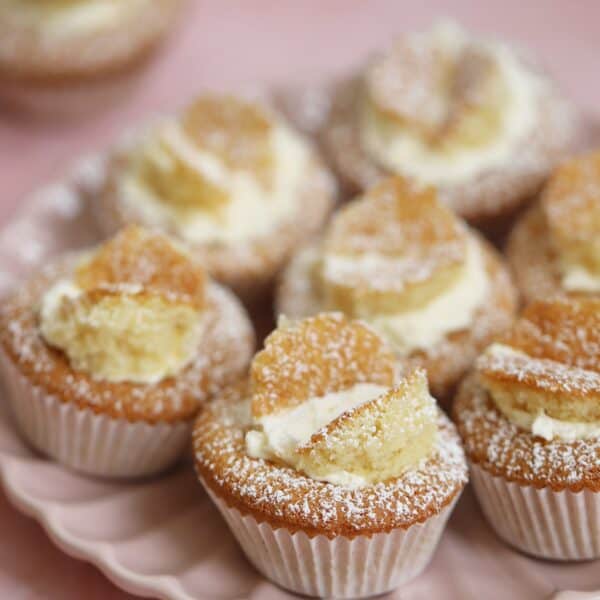 A pink plate with gluten free butterfly cakes on.