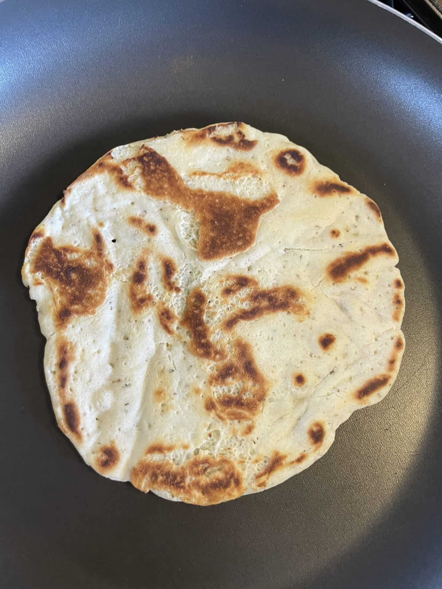 Gluten free naan bread in a pan.