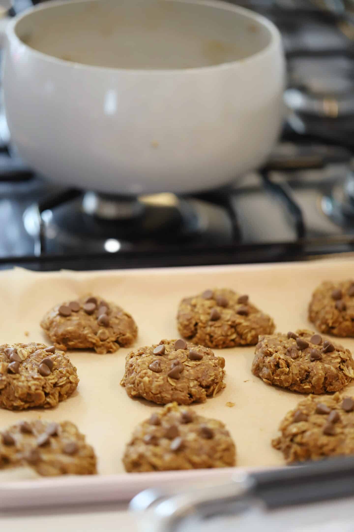 The no bake cookies on the kitchen counter with an empty saucepan behind.