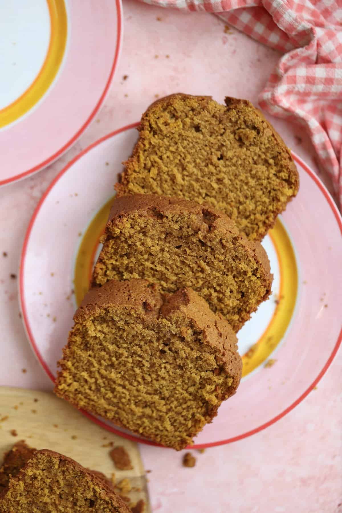 Three slices of gluten free pumpkin bread on a pink plate.