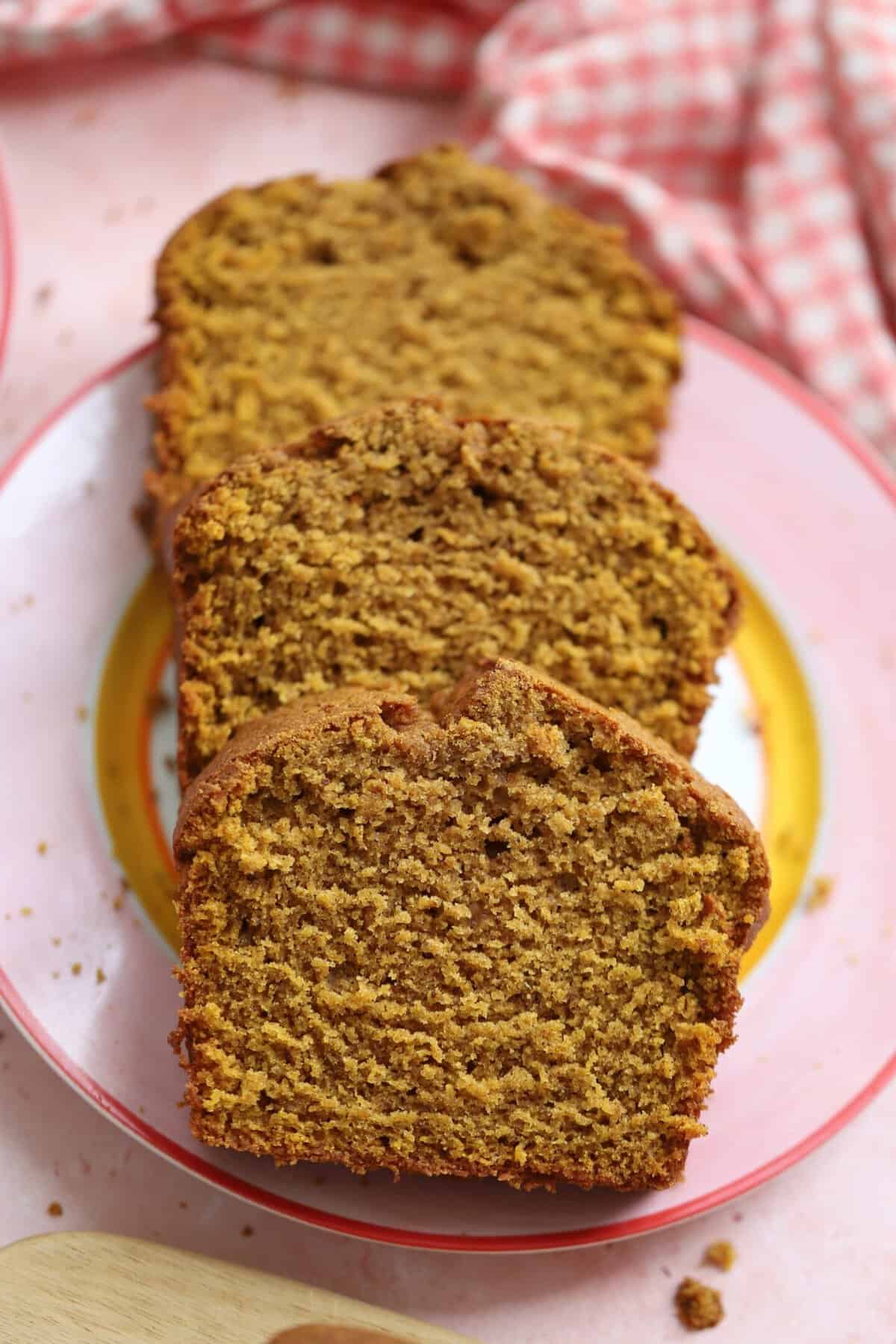 Slices of gluten free pumpkin bread on a pink plate.