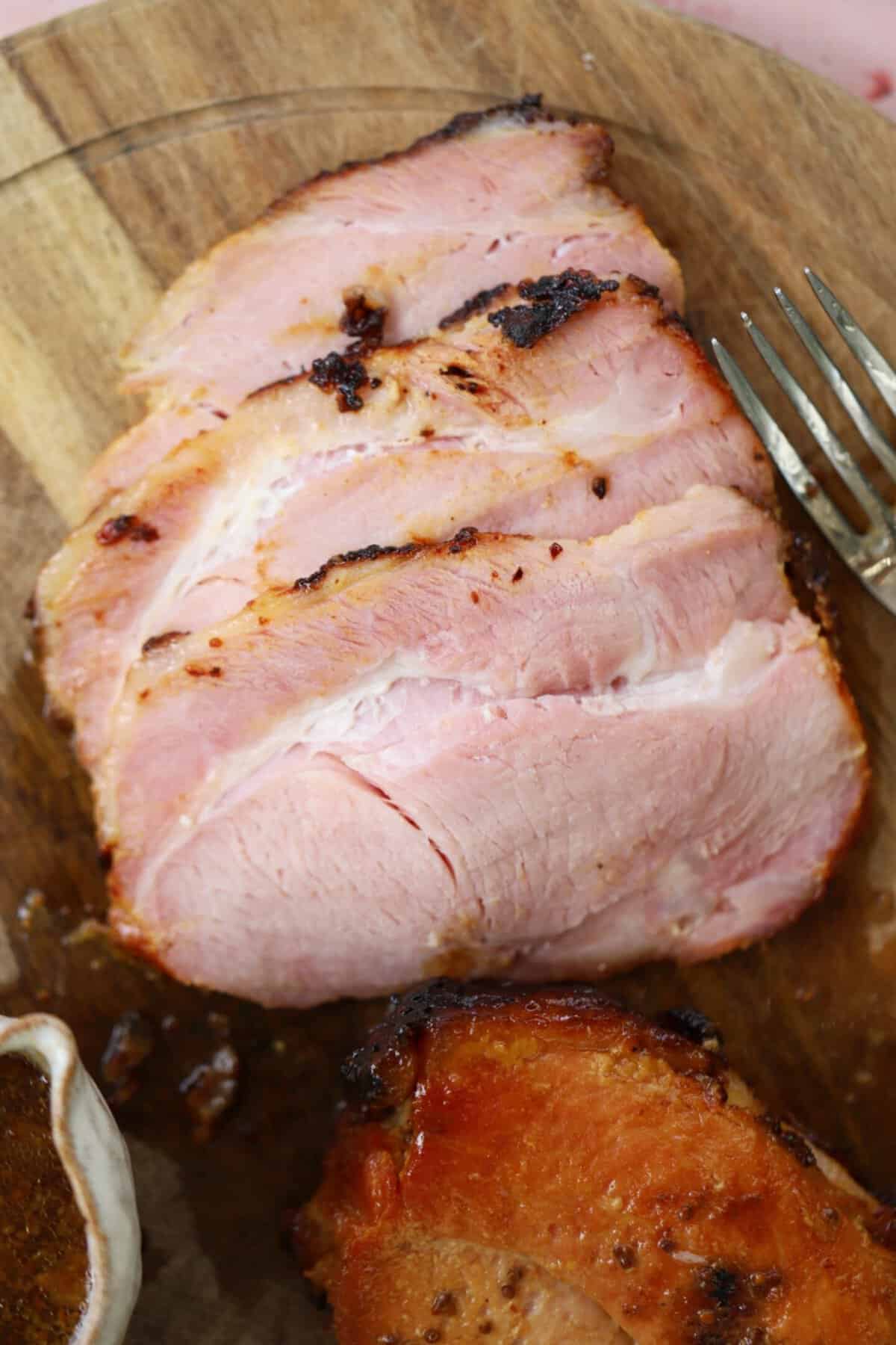 Slices of air fryer gammon on a chopping board.