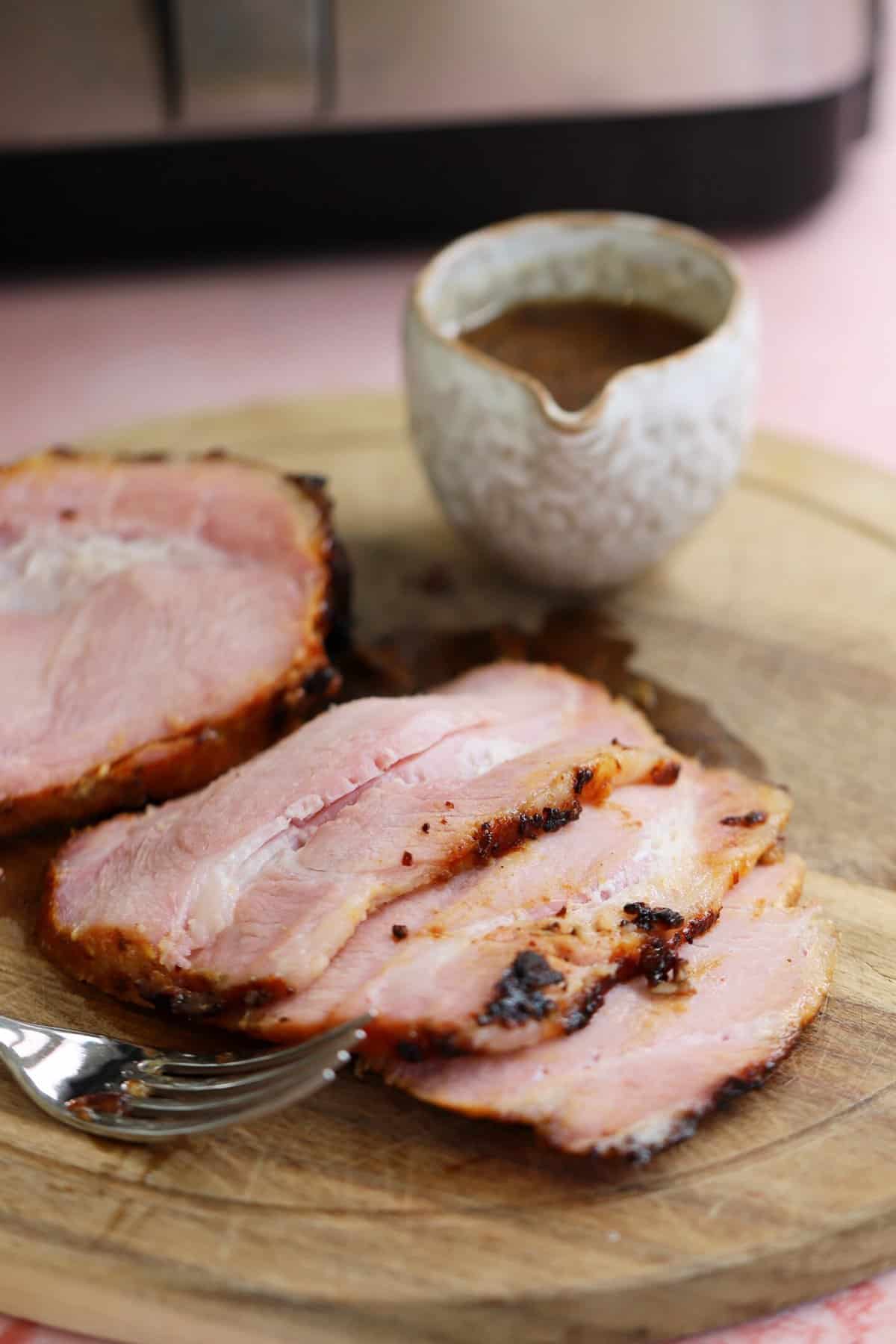 Slices of air fryer gammon on a chopping board.