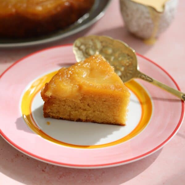 A slice of apple upside down cake on a plate.