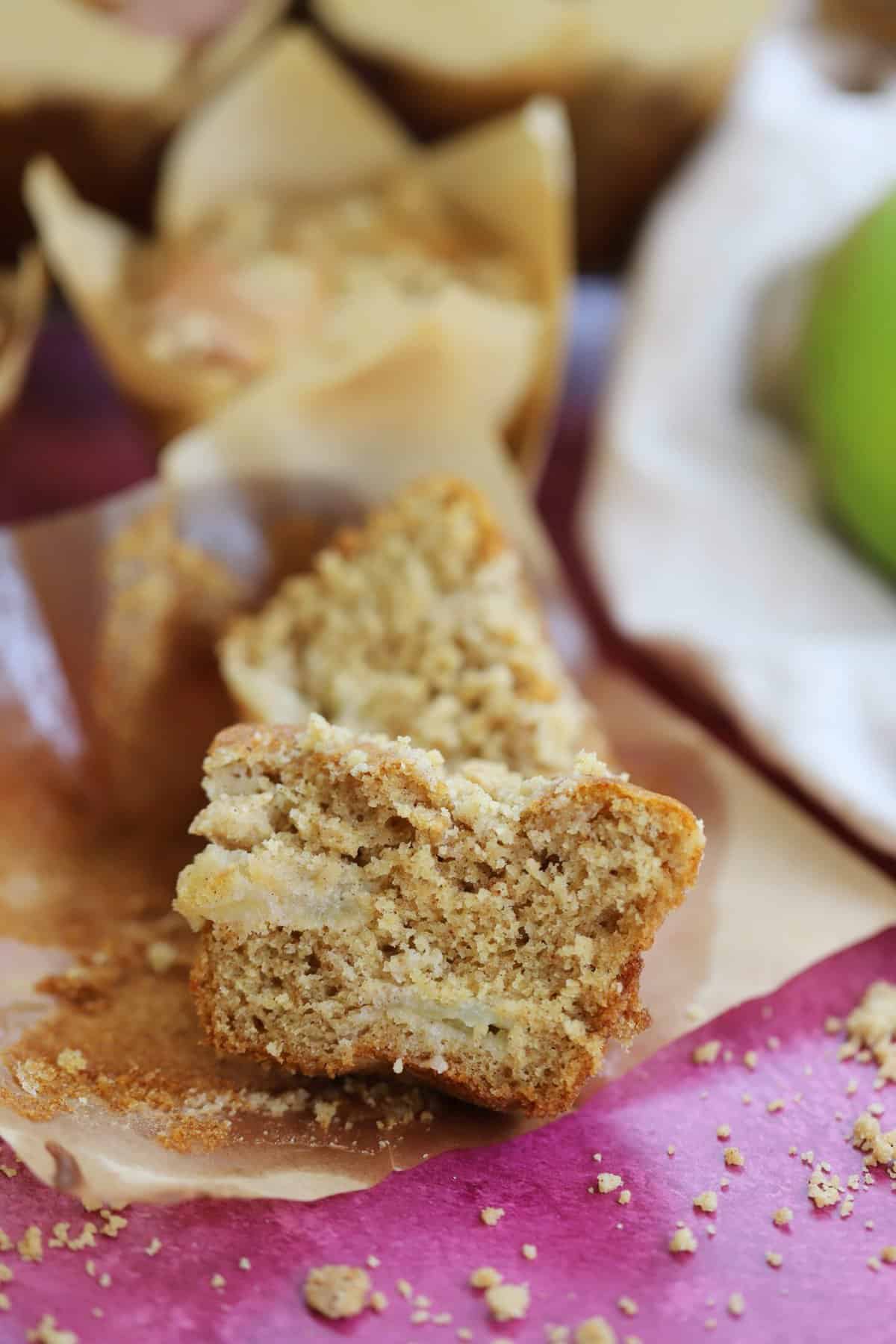 Apple muffin cut in half with chunks of apple inside.