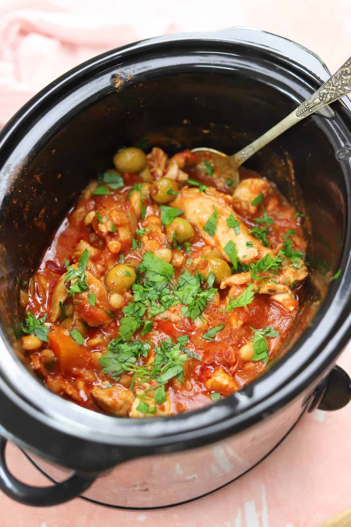 A crock pot full of Spanish chicken stew.