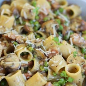 A bowl of creamy ham and mushroom pasta.