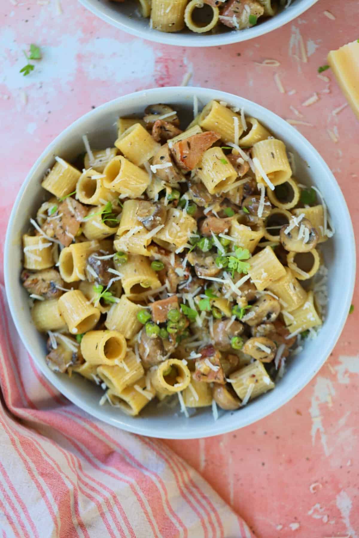 A bowl of creamy ham and mushroom pasta.