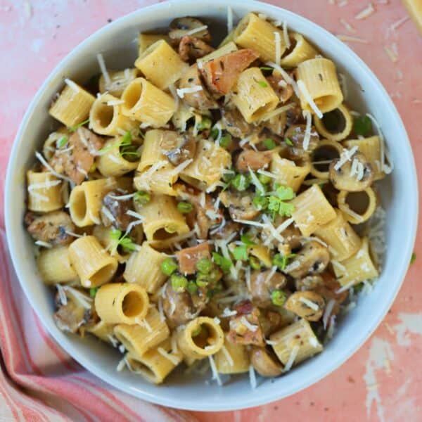 A bowl of creamy ham and mushroom pasta.