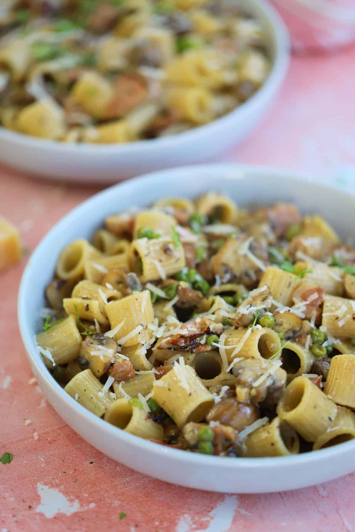 A bowl of creamy ham and mushroom pasta.