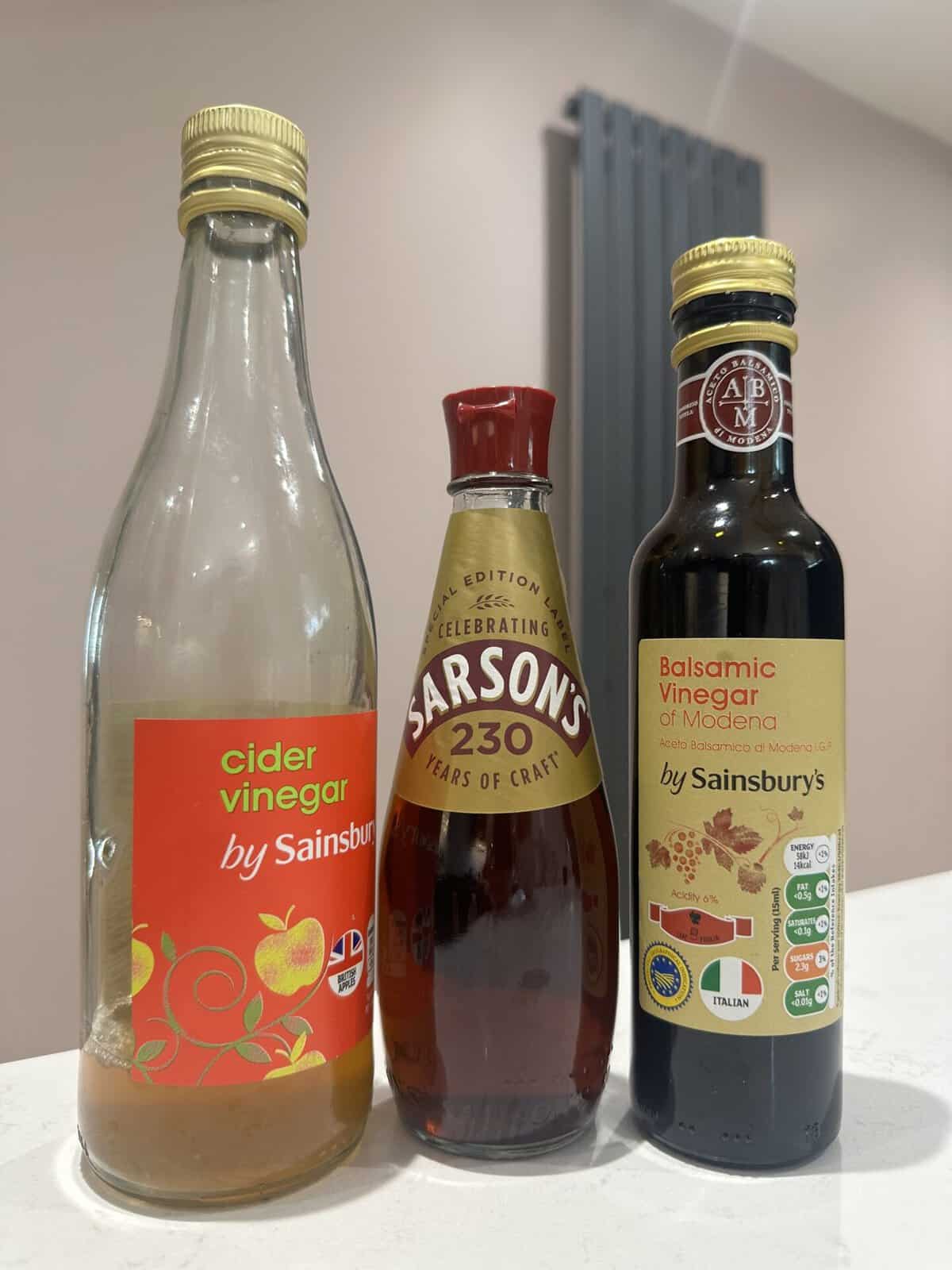 Three bottles of different vinegars.